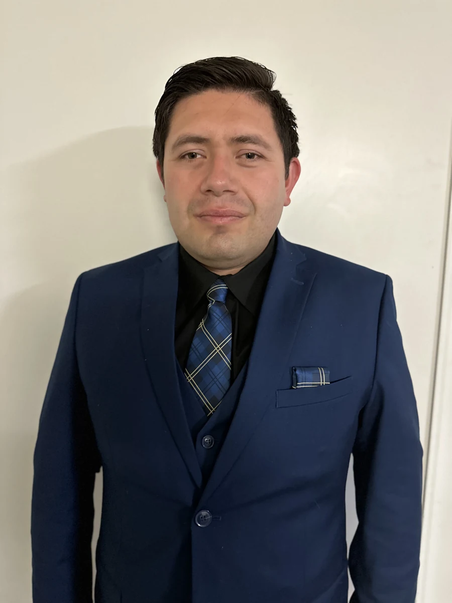 Fernando Macias lleva un traje azul marino y una corbata azul estampada.