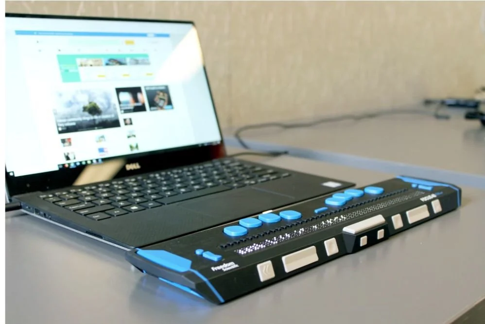 Computadora portátil conectada a una línea braille actualizable.